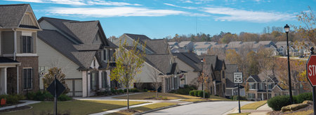 Panorama speed limit at 25 miles on residential street leading down steep hill, row of two-story houses, new development subdivision neighborhood upscale, Atlanta, Georgia, USA. Sunny cloud blue skyの写真素材
