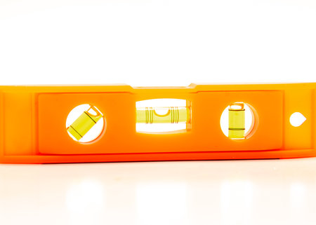Spirit level or bubble torpedo level with magnetic strip, hands-free work on metal surfaces, durable PVC works vertically, horizontally or 45-degree angles isolated white background. Measuring toolの写真素材