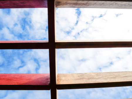 Close-up stained vs original old pergola roof rafter cloud blue sky, house remodel, redwood oil...