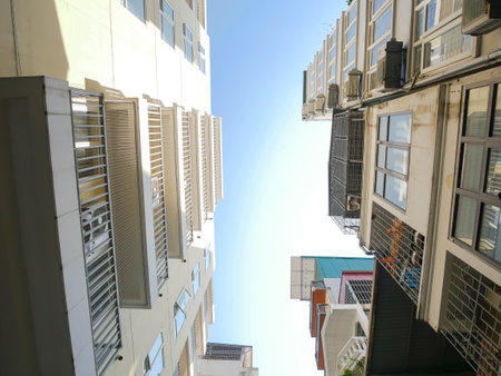 Typical caged-balcony apartment and multistory residential houses at small back alley in downtown...