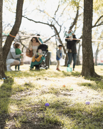 Church backyard with matured tree and load of Easter eggs on green grass field, long line of diverse...