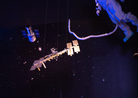 Model of astronaut with safety umbilical cord tethers spacewalk walking round International Space...