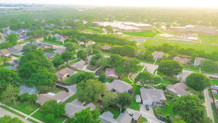Aerial view suburban residential neighborhood with cul-de-sac dead-end keyhole street, lush greenery...