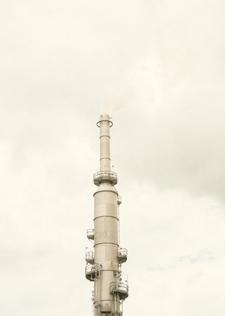 Gas flare or flare stack with clouds of exhaust fumes under overcast sky from crude oil refinery plant in San Antonio, Texas, major source of air pollutants part of refined petroleum products. USAの写真素材