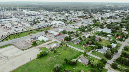 Small agriculture agro-town along highway with large oil refinery complex plant, gas flare, crude oil distillation unit, storage tanks, utility systems, pipelines, San Antonio, Texas, aerial view. USAの写真素材
