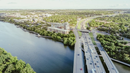 Riverside hotel resort along Colorado River with boardwalk, busy traffic over Highway 35 bridge,...