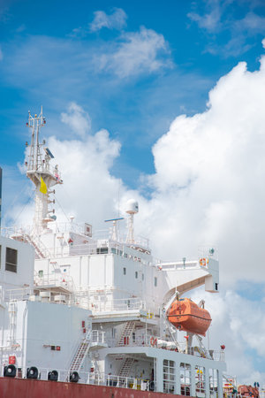 Close-up bridge deck, crane, lifeboat VHF radio frequencies antennas satellite signals navigation radar on large crude oil tanker bulk transport sail thru South Padre Island, Brownsville port, TX. USAの写真素材
