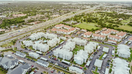 Interstate I-35 busy traffic in northeast of downtown Austin, Texas near colorful painted new apartment complex metal roofings, busy outdoor parking, rental community, housing market, aerial. USAの写真素材