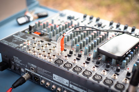 Audio bus mixer connects to smartphone via USB cable interface to broadcast live music performance...