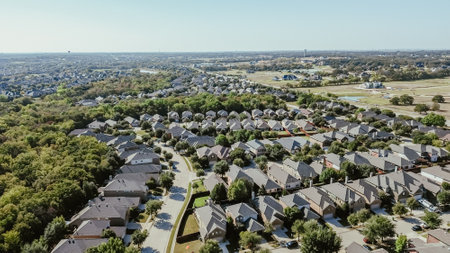 Net zero green community upscale neighborhood row of suburban houses large residential street, well-trimmed landscape, Bartonville and Argyle, Denton County, Texas, water tower background aerial. USAの写真素材