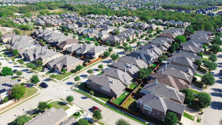 Large scale master planned community row of suburban residential houses in Bartonville and Argyle, Denton County, Texas, two story homes with shingle roofing, compact backyard, lush green trees. USAの写真素材