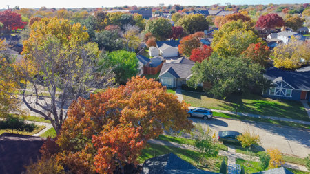 Residential street with colorful fall foliage over suburban houses shingle roofing in Coppell, Dallas Fort Worth, Texas metroplex, fast growing suburbs housing market real estate, aerial view. USAの写真素材