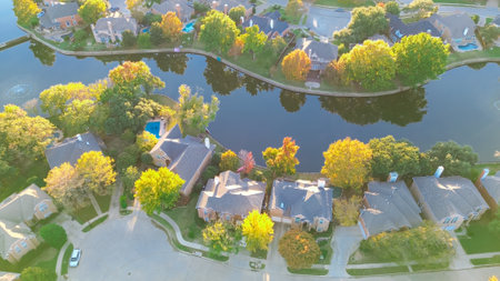 Quiet cul-de-sac dead-end keyhole shape street in upscale lakeside neighborhood water fountain in Coppell, suburbs Dallas, Texas, large single-family houses swimming pools, autumn leaves, aerial. USAの写真素材