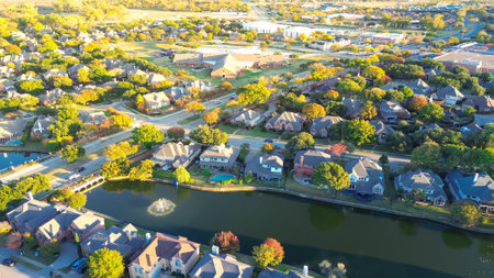 Suburban school district in upscale lakeside residential community along MacArthur boulevard in Coppell, suburbs Dallas, Texas, colorful autumn leaves over row of two story large suburban houses. USAの写真素材