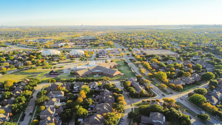 City large water tanks ground storage and elementary school in Coppell residential neighborhood with downtown Las Colinas Irving Texas in background, colorful fall foliage autumn leaves, aerial. USAの写真素材