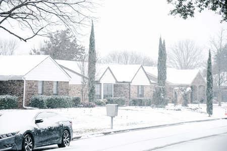 Group mailbox on neighborhood street and sidewalk under snow covered during heavy winter storm in...