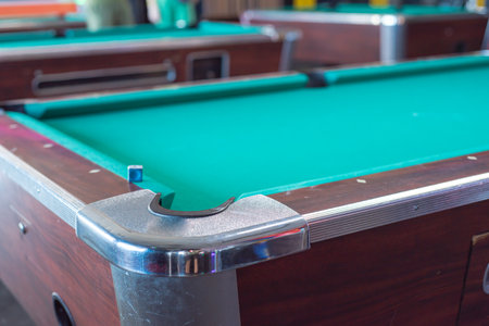 Multiple pool tables with pockets and accessory sets at indoor game room in Houston, Texas, green...