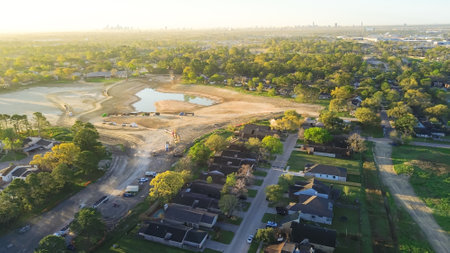 Heavy equipment, dump trucks, cranes at construction site stormwater detention basins to provide flood damage reduction during heavy storm Antoine Dr, Inwood Forest golf course in North Houston. USAの写真素材