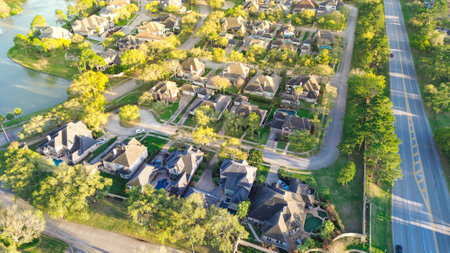Lush green North Eldridge Parkway along upscale gated community in unincorporated area northwestern Harris County, Houston, Texas, row of expensive mansion homes with swimming pools, aerial view. USAの写真素材