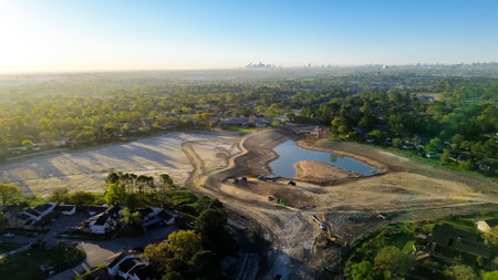 North Houston residential area with downtown skyline background and stormwater detention basins project construction site, heavy equipment, dump trucks, cranes moving crushing waste, dirt, aerial. USAの写真素材