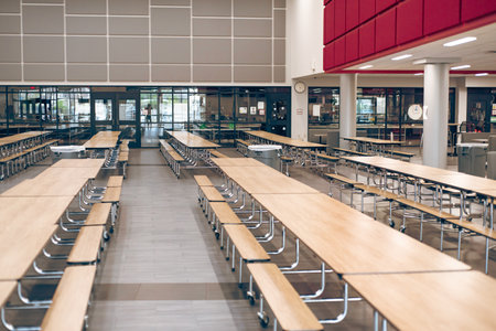 Empty rectangle mobile cafeteria table with bench seats for easy sit close or spread out at middle school in Dallas, Texas, laminate top resists scratches and stains, powder-coated steel frame. USAの写真素材