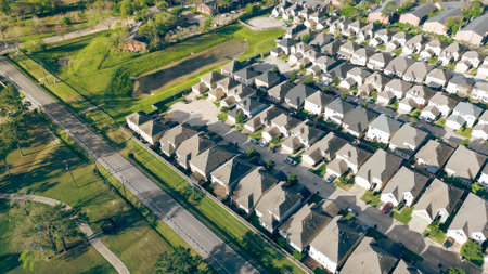 Peaceful country road and power lines near new construction row of two-story single-family houses, strata landed housing cluster in Fairbanks and Northwest Crossing neighborhood, Houston, aerial. USAの写真素材