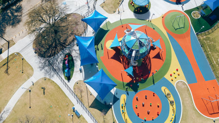 Colorful outdoor playground with climbing sphere, swings, zipline, obstacle courses, children...