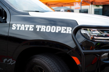 Side view black SUV State Trooper patrol vehicle with push bumper steel frames mounted used to push disabled vehicles away from danger or clear the roadway ensuring public safety, police bullbars. USAの写真素材