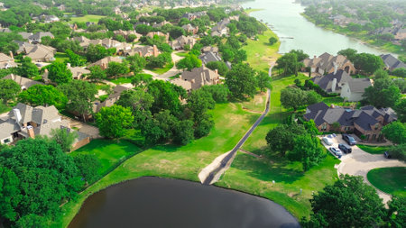 Concrete drainage channel and pond detention stormwater flood control in wealthy waterfront residential area western branch of Lewisville Lake, large two-story homes in Highland Village, Texas. USAの写真素材