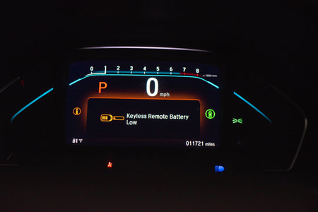 Keyless remote battery low warning indicator on illuminated dashboard of modern minivan car in...