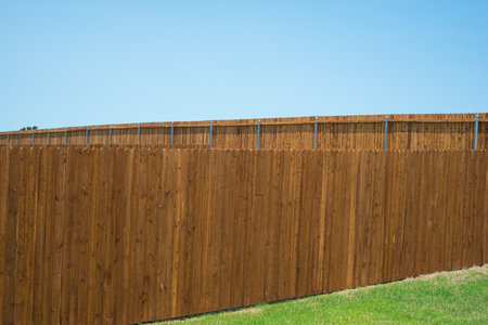 Brand new wooden fence in natural exterior wood stains and round fence post powder coating of new construction home in Princeton, Collin County, Texas, backyard residential privacy, suburbs Dallas. USの写真素材