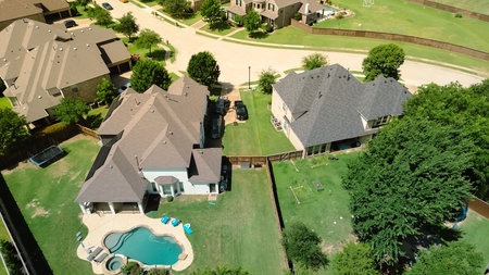 Luxury modern suburban home with spacious fenced backyard, resort style swimming pool, patio furniture, open lawn space designed for family recreation and outdoor relaxation in Flower Mound, Texas. USの写真素材