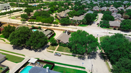 Dallas suburbs single family houses with backyard pools next to large industrial warehouses, separated by greenbelt of trees, power lines, buffer between residential areas and distribution hubs. USAの写真素材