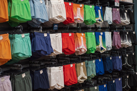 Vibrant array of female athletic, stride high-rise shorts displayed in sporty retail setting, showcasing color options and styles. Organized layout highlights diverse selection active lifestyles. USAの写真素材