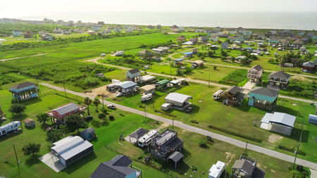 Boyt Beach in Port Bolivar, Texas with elevated vacation rental, scenic ocean views and storm-safe design. Surrounded by open green lawn, blends relaxed coastal living with real estate potential. USAの写真素材