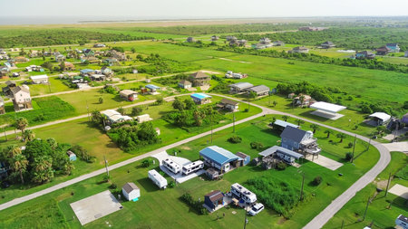 RVs and trailers parked across lots near Beach Boyt in Port Bolivar, Texas, mix of permanent residents and vacationers. Community arranged in open layout with maintained lawns, gravel paved road. USAの写真素材