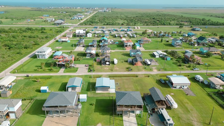 Colorful raised houses and RVs, trailers near Beach Boyt in Port Bolivar, Texas, large grassy lots and ocean views evoke relaxed coastal lifestyle blending vacation homes and storm-safe design. USAの写真素材