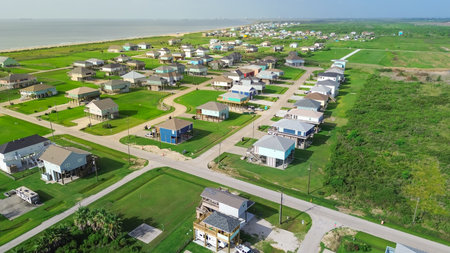 Colorful raised houses and RVs, trailers near Beach Boyt in Port Bolivar, Texas, large grassy lots and ocean views evoke relaxed coastal lifestyle blending vacation homes and storm-safe design. USAの写真素材