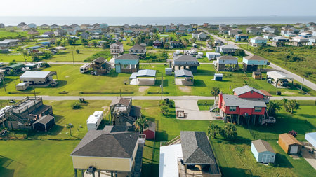 Colorful raised houses and RVs, trailers near Beach Boyt in Port Bolivar, Texas, large grassy lots and ocean views evoke relaxed coastal lifestyle blending vacation homes and storm-safe design. USAの写真素材