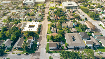 Aerial view Galveston features homes, courtyard-style apartments, large multilevel parking garage....