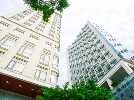 Low-angle view of contrasting buildings in Danang, one with classical beige facade and ornate...