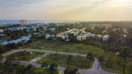 Scenic Santa Rosa Beach coastal community with dense white rooftops and ocean backdrop. Foreground shows vacant land, highlighting development potential, urban expansion near shoreline, Florida. USAの写真素材