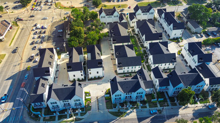 Cooper and Abram, Main Street intersection in Arlington, Texas with gated townhomes, retail storefronts, gas station converge near college campus, dense mixed-use development and transit access. USAの写真素材