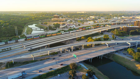 Early morning at Fort Worth showing freight train crossing Trinity River alongside highway leading...