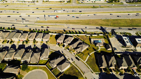 Busy Highway 121 near upscale Castle Hills neighborhood with two-story homes, fenced yards, HOA pool. Tollway and frontage road separate residential zone from corner retail and commercial pads. USAの写真素材