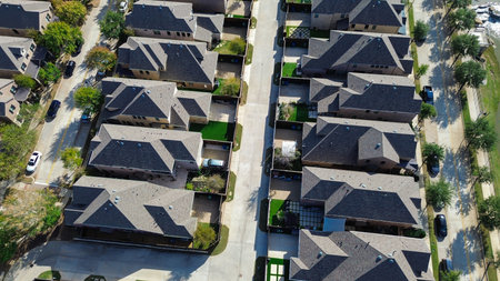 Gray-shingled homes arranged in grid with driveways, parked cars, tree-lined sidewalks reflect well-maintained, organized suburban development consistent architectural style, Flower Mound, Texas. USAの写真素材