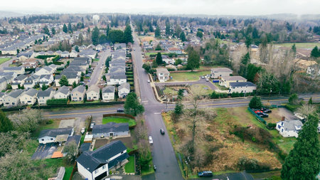 Subdivision in East Hill neighborhood near Panther Lake area blends open yards, sheds, and tree clusters. Mossy shingles, muted grass, and cool seasonal light settle across Kent, Washington. USAの写真素材