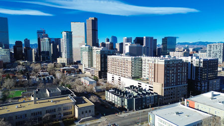 Uptown corridors stretch toward the central business district along 17th St. Bright skies emphasize reflective glass tower facades, varied roof textures and dormant branches, Denver, Colorado. USAの写真素材