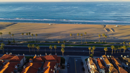 Beachfront corridor along PCH parallels wide Huntington City Beach shoreline near 15th St, northern...