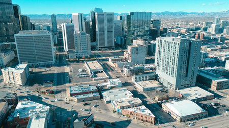 Midrise residential developments frame downtown skyline, showcasing oldworld charm contemporary growth. Crisp visibility reveals facade details etched against mountainlined horizon of Denver, CO. USA